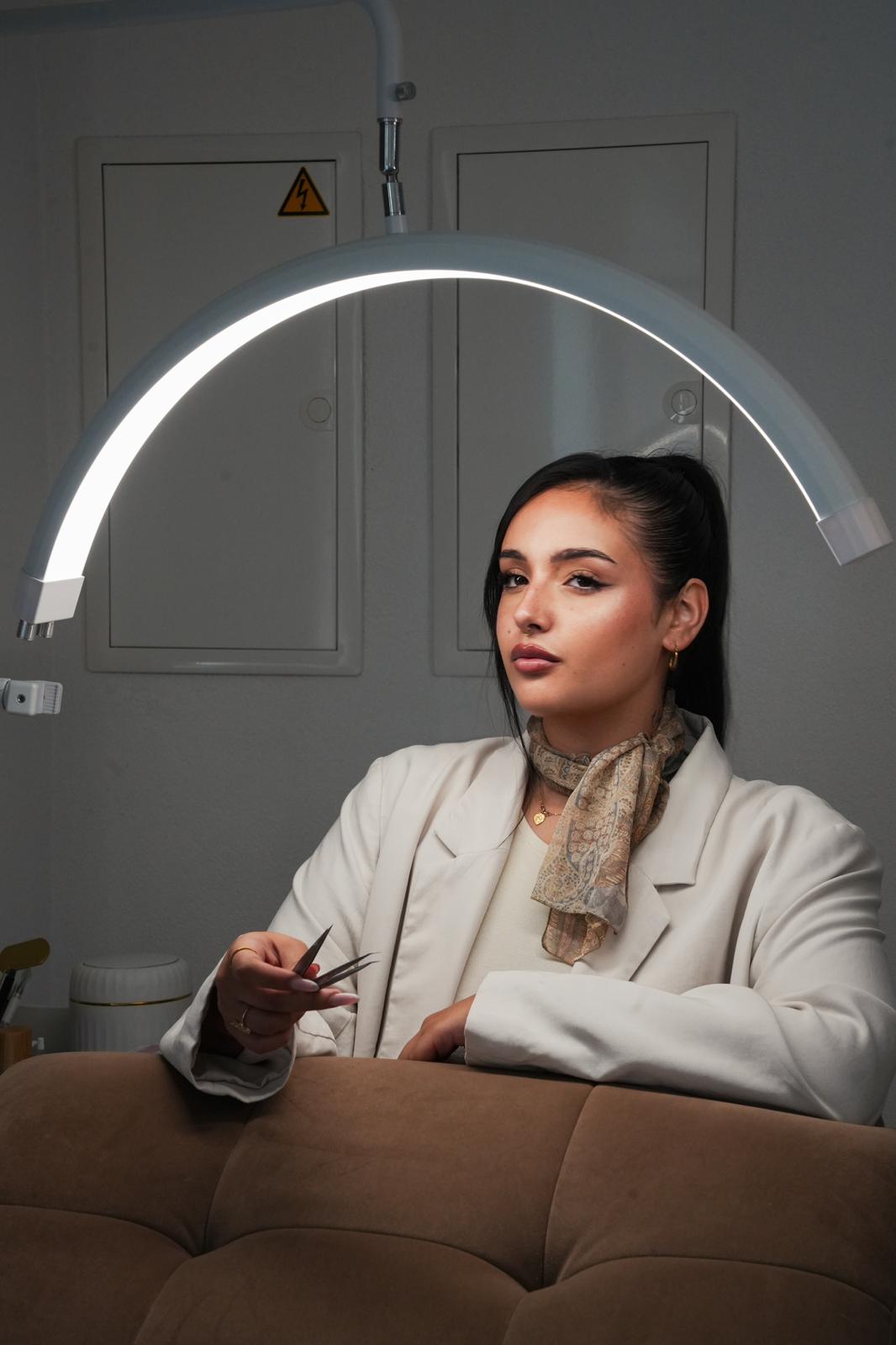 Alessia Lombardo nel suo studio con pinzette sotto la lampada da lavoro